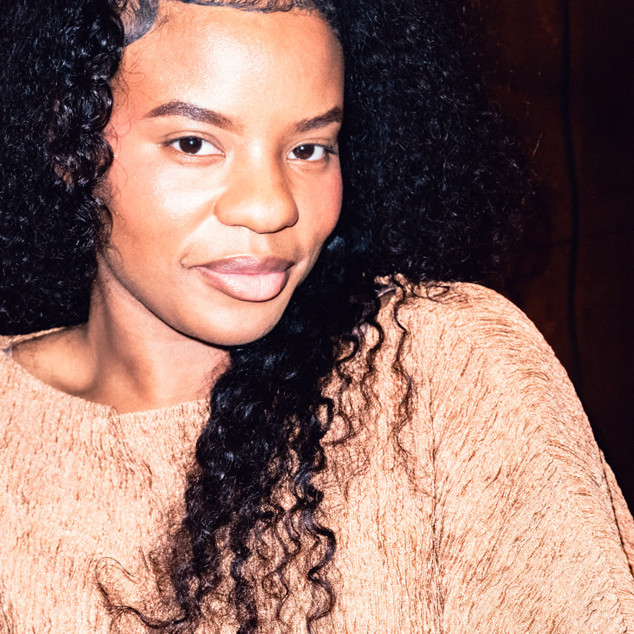 Direct-flash portrait of a model in a textured peach look