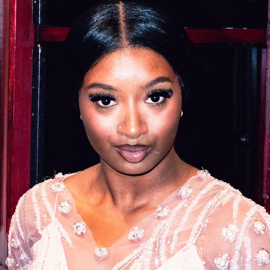 Model in a pale embellished look posing backstage